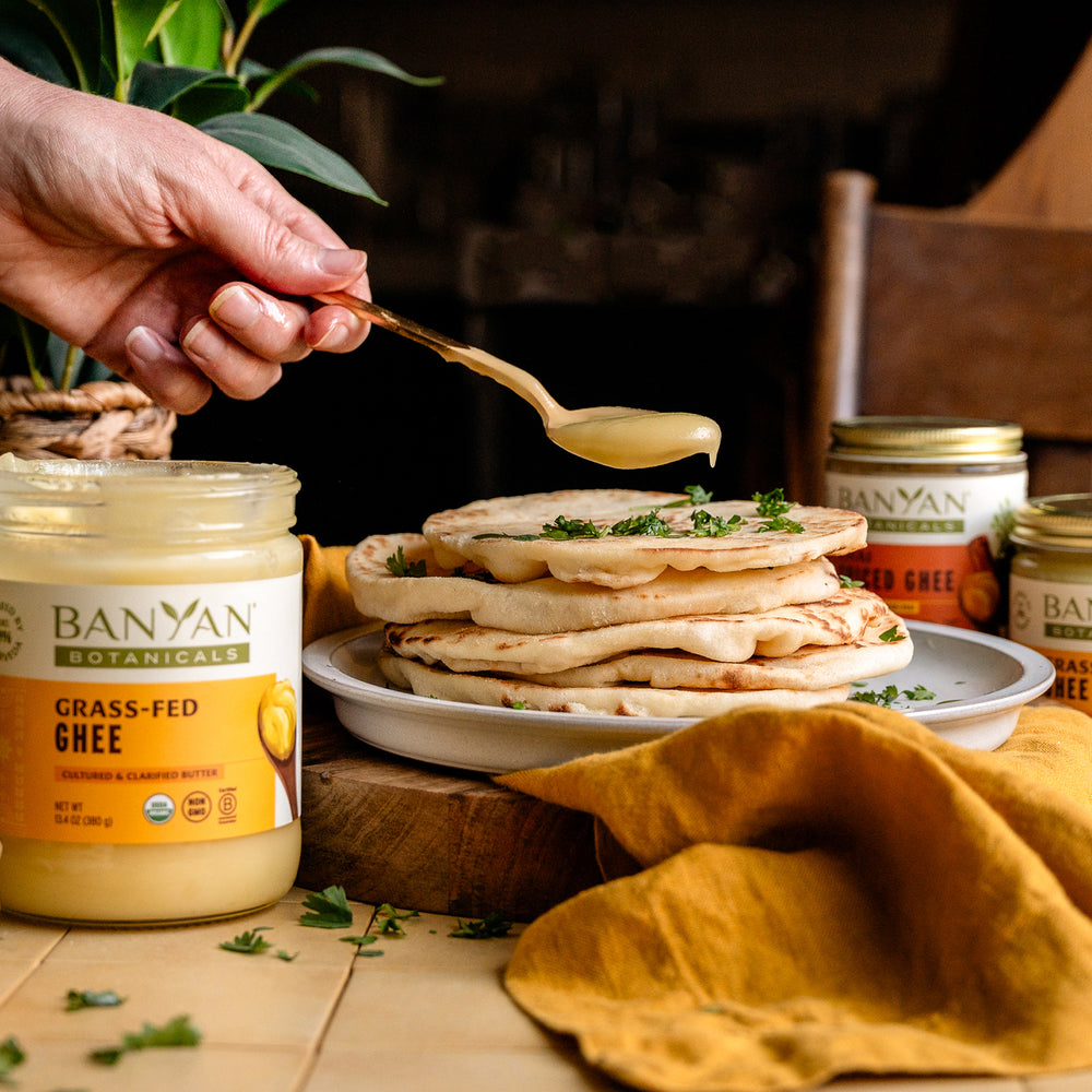 someone putting a spoon or Organic Ghee on flat bread