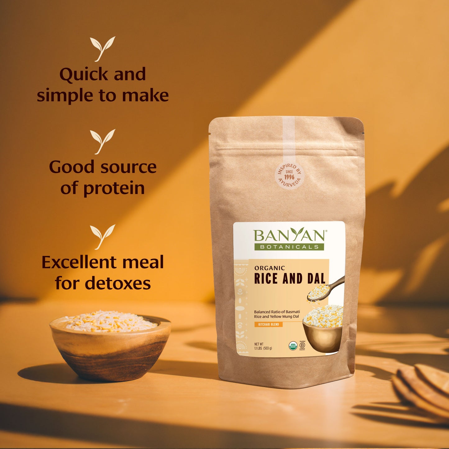 Banyan Botanicals Organic Rice and Dal package on a wooden surface with text about its benefits.